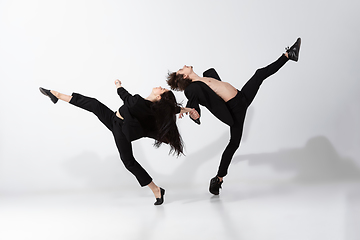 Image showing Young and graceful ballet dancers in minimal black style isolated on white studio background