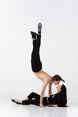 Image showing Young and graceful ballet dancers in minimal black style isolated on white studio background