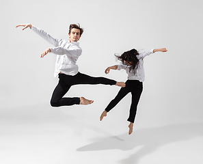 Image showing Young and graceful ballet dancers in minimal black style isolated on white studio background