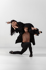 Image showing Young and graceful ballet dancers in minimal black style isolated on white studio background