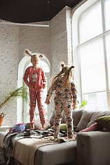 Image showing Quiet little girls playing in a bedroom in cute pajamas, home style and comfort, laughting and fighting pillows, jumping high