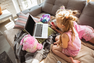 Image showing Quiet little girls playing in a bedroom in cute pajamas, home style and comfort, watching cartoons, cinema, having fun