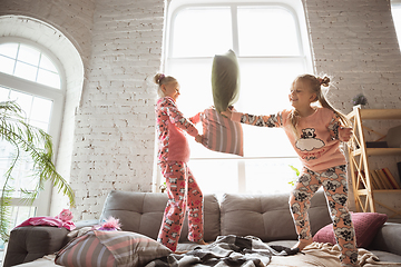 Image showing Quiet little girls playing in a bedroom in cute pajamas, home style and comfort, laughting and fighting pillows