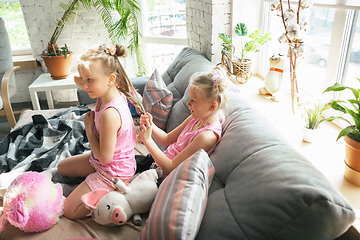 Image showing Quiet little girls playing in a bedroom in cute pajamas, home style and comfort, making a hairstyle