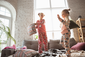 Image showing Quiet little girls playing in a bedroom in cute pajamas, home style and comfort, laughting and fighting pillows