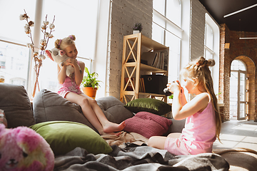 Image showing Quiet little girls playing in a bedroom in cute pajamas, home style and comfort, taking a photo