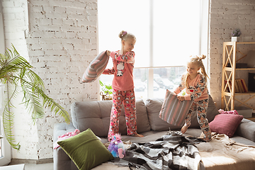 Image showing Quiet little girls playing in a bedroom in cute pajamas, home style and comfort, laughting and fighting pillows