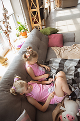Image showing Quiet little girls playing in a bedroom in cute pajamas, home style and comfort, watching cartoons, cinema, having fun