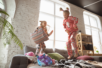 Image showing Quiet little girls playing in a bedroom in cute pajamas, home style and comfort, laughting and fighting pillows, jumping high