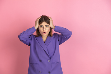 Image showing Caucasian young woman\'s portrait on pink studio background, emotional and expressive