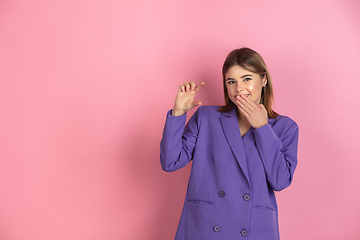 Image showing Caucasian young woman\'s portrait on pink studio background, emotional and expressive