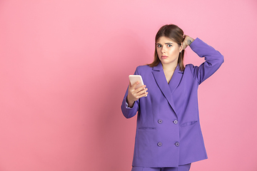 Image showing Caucasian young woman\'s portrait on pink studio background, emotional and expressive