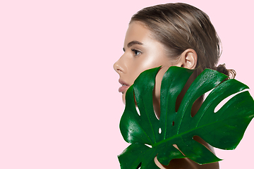 Image showing Best attire. Close up of beautiful young woman with green leaves on her face over white background. Cosmetics and makeup, natural and eco treatment, skin care