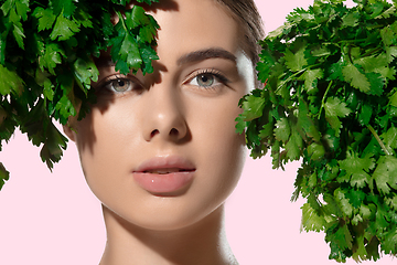 Image showing Fresh. Close up of beautiful young woman with green leaves on her face over white background. Cosmetics and makeup, natural and eco treatment, skin care