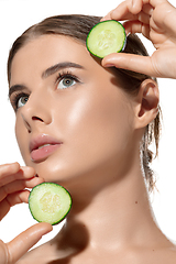 Image showing Green. Close up of beautiful young woman with fresh cucumber slices over white background. Cosmetics and makeup, natural and eco treatment, skin care