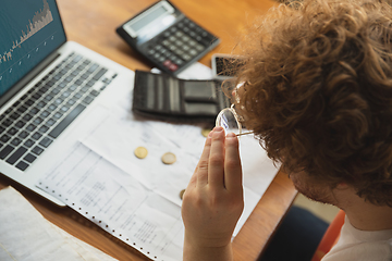 Image showing Close up caucasian upset and despair man doing financial and economical reports with income graphs going down during coronavirus quarantine, problems, empty wallet