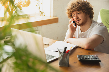 Image showing Caucasian upset and despair man watching financial and economical reports with income graphs going down during coronavirus quarantine. Problems, empty wallet