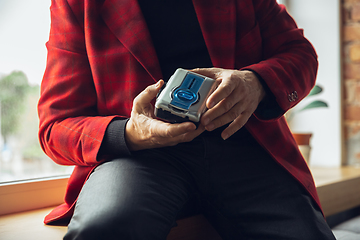 Image showing Close up of senior man with retro toys, meeting things from the past and having fun, exploring the lifestyle of the nineties, using cassette player