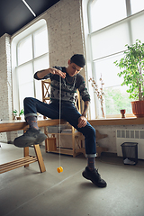 Image showing Portrait of millenial boy using retro toys, meeting things from the past and having fun, exploring yo-yo game