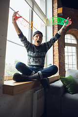 Image showing Portrait of millenial boy using retro toys, meeting things from the past and having fun, exploring rainbow spring toy