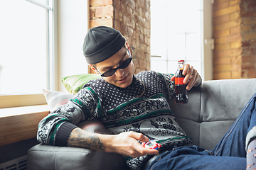 Image showing Portrait of millenial boy using retro toys, meeting things from the past and having fun, exploring tamagotchi, virtual pet game