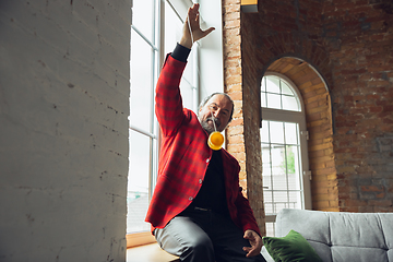 Image showing Portrait of senior man with retro toys, meeting things from the past and having fun, exploring the lifestyle of the nineties, playing with yo-yo