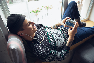 Image showing Portrait of millenial boy using retro toys, meeting things from the past and having fun, exploring music cassette player