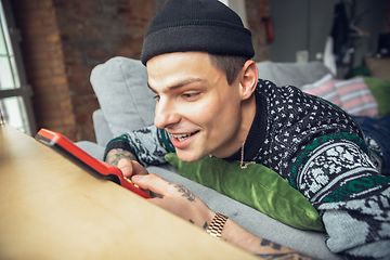 Image showing Portrait of millenial boy using retro toys, meeting things from the past and having fun, exploring tetris game