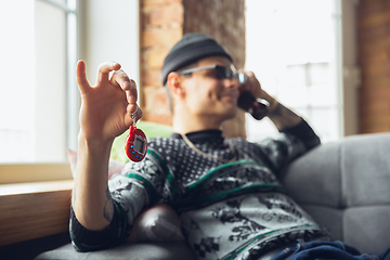 Image showing Portrait of millenial boy using retro toys, meeting things from the past and having fun, exploring tamagotchi, virtual pet game