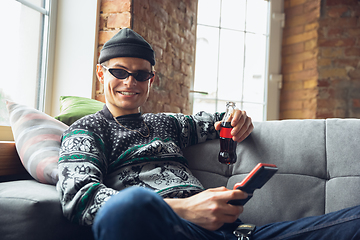 Image showing Portrait of millenial boy using retro toys, meeting things from the past and having fun, exploring tetris game