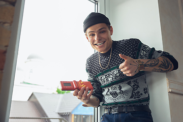 Image showing Portrait of millenial boy using retro toys, meeting things from the past and having fun, exploring tetris game