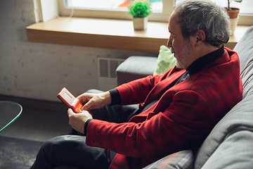 Image showing Portrait of senior man with retro toys, meeting things from the past and having fun, exploring the lifestyle of the nineties, playing with tetris