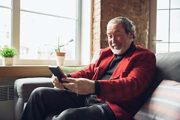 Image showing Portrait of senior man with retro toys, meeting things from the past and having fun, exploring the lifestyle of the nineties, playing with tetris