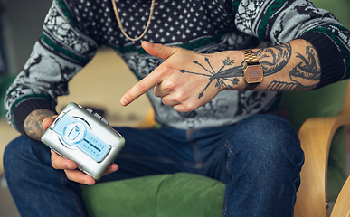 Image showing Close up of millenial boy using retro toys, meeting things from the past and having fun, exploring music cassette player