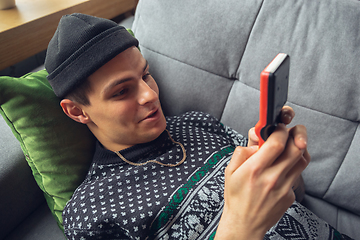 Image showing Portrait of millenial boy using retro toys, meeting things from the past and having fun, exploring tetris game