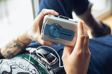 Image showing Close up of millenial boy using retro toys, meeting things from the past and having fun, exploring music cassette player