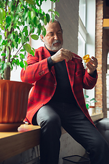 Image showing Portrait of senior man with retro toys, meeting things from the past and having fun, exploring the lifestyle of the nineties, playing with yo-yo