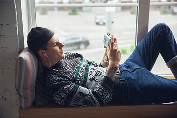 Image showing Portrait of millenial boy using retro toys, meeting things from the past and having fun, exploring music cassette player