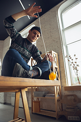 Image showing Portrait of millenial boy using retro toys, meeting things from the past and having fun, exploring yo-yo game