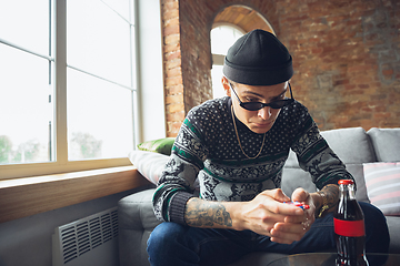 Image showing Portrait of millenial boy using retro toys, meeting things from the past and having fun, exploring tamagotchi, virtual pet game