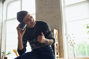 Image showing Portrait of millenial boy using retro toys, meeting things from the past and having fun, exploring music cassette player