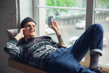 Image showing Portrait of millenial boy using retro toys, meeting things from the past and having fun, exploring music cassette player