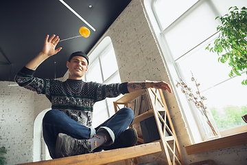 Image showing Portrait of millenial boy using retro toys, meeting things from the past and having fun, exploring yo-yo game