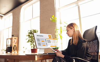 Image showing Woman using devices for job looking during worldwide crisis of coronavirus pandemic. Find a job online. Business, internet and networking concept.