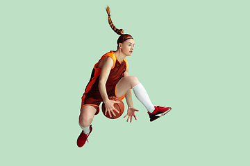 Image showing Young caucasian female basketball player against mint colored studio background