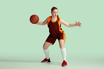 Image showing Young caucasian female basketball player against mint colored studio background