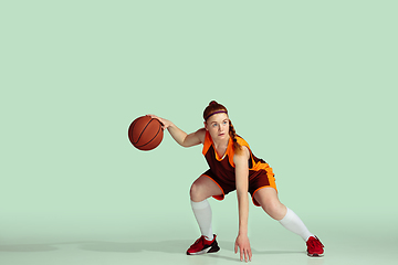 Image showing Young caucasian female basketball player against mint colored studio background