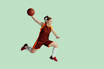 Image showing Young caucasian female basketball player against mint colored studio background