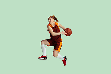 Image showing Young caucasian female basketball player against mint colored studio background