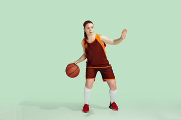 Image showing Young caucasian female basketball player against mint colored studio background